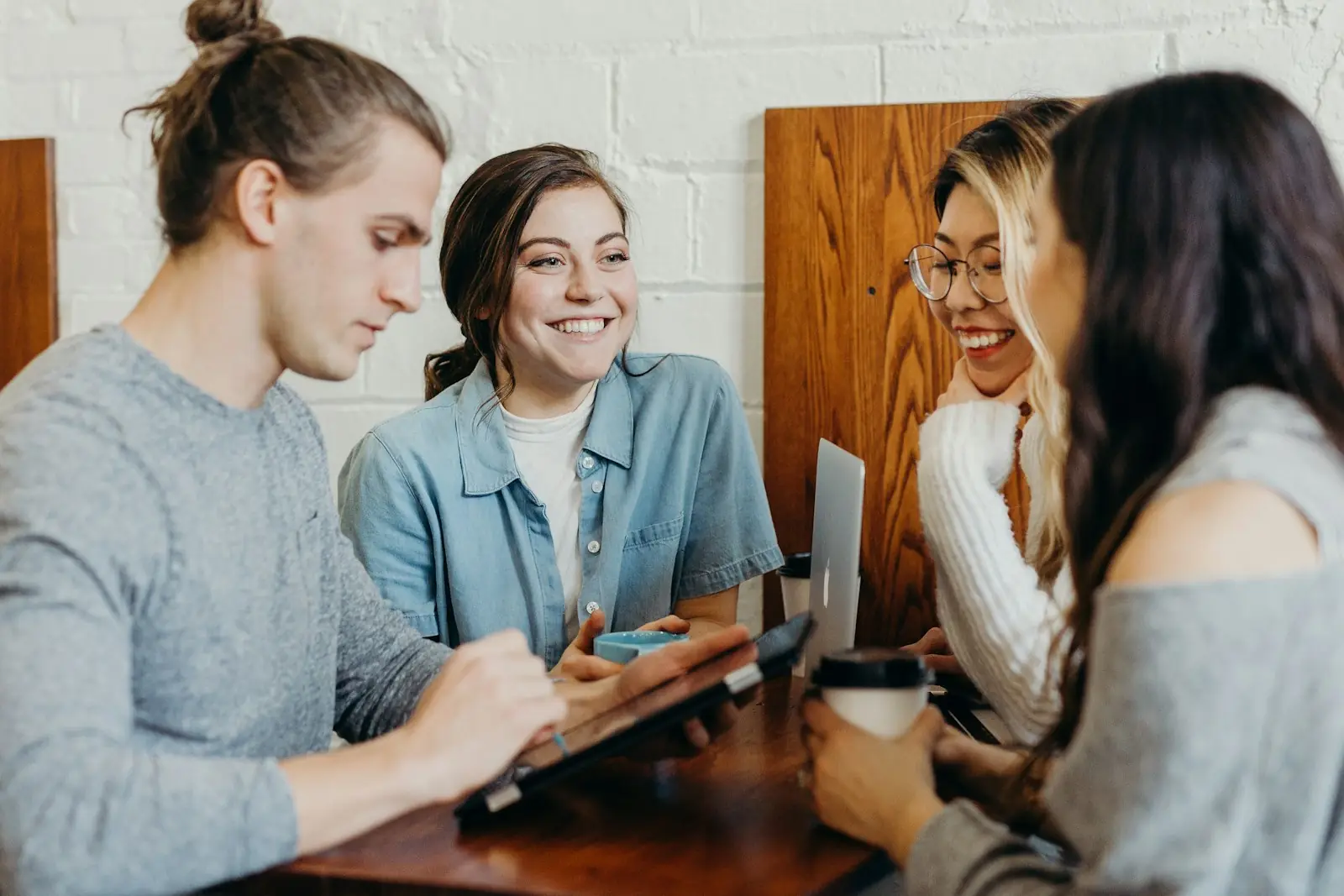 Equipe reunida olhando um tablet e sorrindo